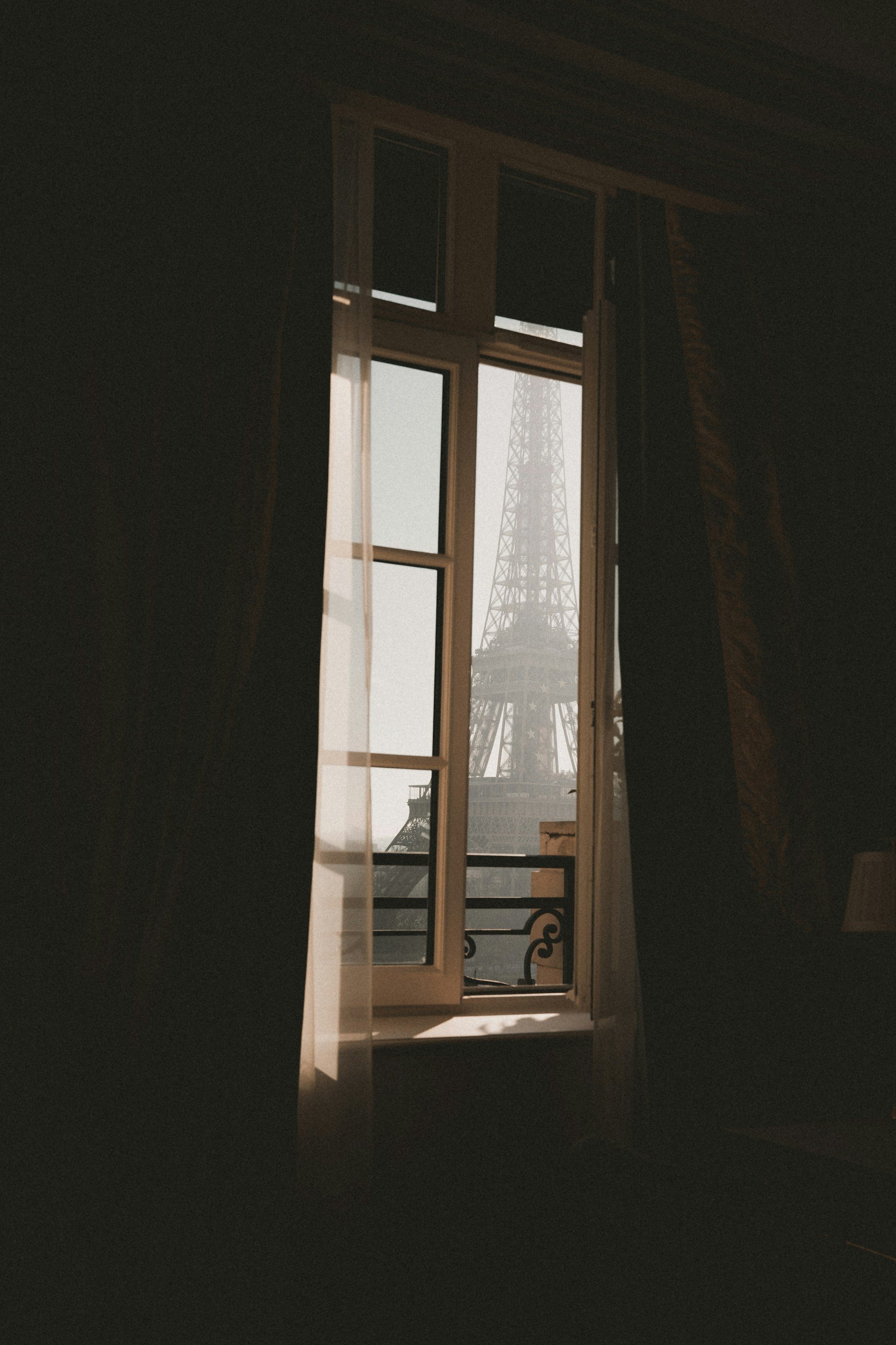 Wedding Website Design, Digital Wedding Stationery, Web Design and Branding for Wedding Professionals | Avelã White. View of the Eiffel Tower through a window with curtains.